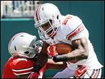  Grey running back Warren Ball  breaks a tackle by Scarlet linebacker David Perkins on Saturday.