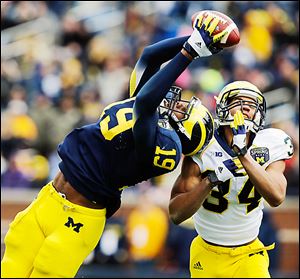 Michigan tight end Devin Funchess makes a catch against safety Jeremy Clark to help set up a score.
