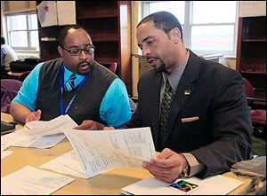 Romules Durant, right, reviews a report with David Manley, special education coordinator-supervisor for Rogers High School, during a recent meeting at the Toledo Technology Academy in West Toledo.