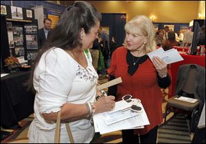Perrysburg resident Sharon Thomas, left, speaks with Let's Travel, Too, LLC travel consultant Nancy Jean Rust at the Commerce Expo 2013 at Levis Commons Hilton Garden Inn.
