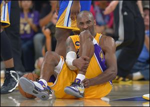 Los Angeles Lakers guard Kobe Bryant grimaces after being injured during the second half Friday against the Golden State Warriors in Los Angeles. The Lakers won 118-116.