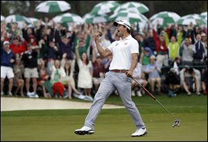 Adam Scott celebrates after a birdie putt on the 18th green during the fourth round of the Masters golf tournament Sunday in Augusta, Ga. He won the Masters in 2-hole playoff, becoming the first Australian to win the event.