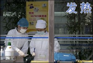Nurses collect patients' blood samples at a specialized fever clinic inside the Ditan Hospital, where a Chinese girl is being treated for the H7N9 strain of bird flu, in Beijing today.