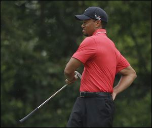 Tiger Woods stretches before putting on the fourth green during the fourth round of the Masters golf tournament Sunday in Augusta, Ga. Woods shot 2-under 70 for the third time in four rounds, not enough to win his fifth green jacket.