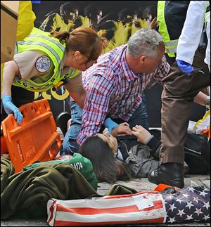 Medical workers aid injured people following an explosion at the marathon.