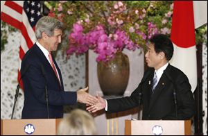 U.S. Secretary of State John Kerry shakes hands with Japanese Foreign Minister Fumio Kishida in Tokyo. Japan said Sunday that it is open to talks with North Korea if Pyongyang honors previous agreements.