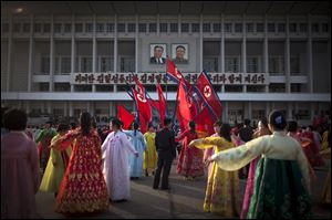 A man, center, supervises a dancing group  during a mass folk dance in front of the Pyongyang Indoor Stadium in Pyongyang, North Korea, today.