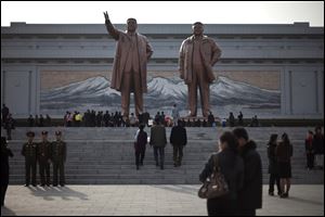 People visit statues of the late North Korean leaders Kim Il Sung, left, and Kim Jong Il to celebrate the 101st birthday of Kim Il Sung in Pyongyang, North Korea today.
