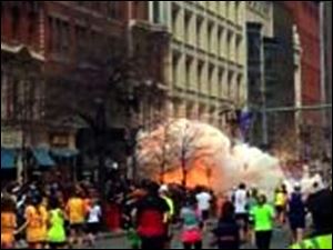 In this image from video by WBZ-TV, spectators and runners flee from what was described as twin explosions that shook the finish line of the Boston Marathon.