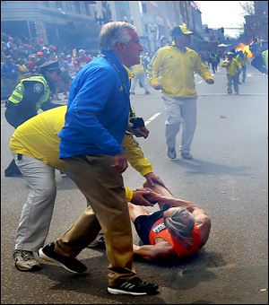 People react to a second explosion today at the 2013 Boston Marathon in Boston. Two explosions shattered the euphoria of the Boston Marathon finish line on Monday, sending authorities out on the course to carry off the injured while the stragglers were rerouted away from the smoking site of the blasts.