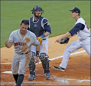 Tony Sanchez of Indianapolis reacts to scoring before a tag by Hens catcher Bryan Holaday as pitcher Pat Misch disagrees with the call.