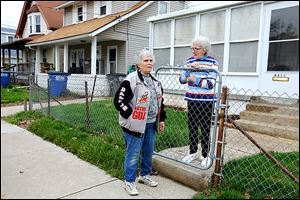 Neighbors Clara Sneed, left, and Gloria Ryan talk about the deaths of Kim Hassler, 48, and her son, Andrew Hassler, 11, in the garage at the home to the left of Mrs. Ryan’s home Tuesday.