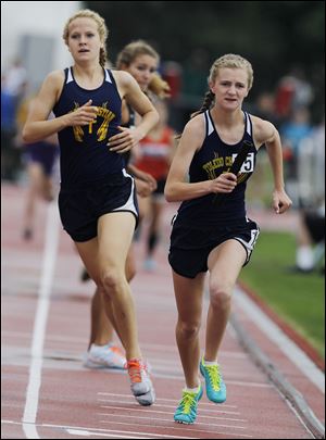 Toledo Christian's Delainey Phelps takes the baton after the exchange with Michelle Wright in the 1600-meter relay at last year's state meet. The Eagles won the race. 