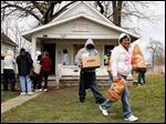  Carla Glover of Toledo carries food to her car after members of the New Light Shiningstar Food Pantry and the Circle of Friends minority health program handed out boxes of food to those in need Wednesday. The two agencies are drawing awareness to the services their organizations provide.