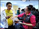 Start High seniors Marcus Johnson and Maria Parraz play a bingo game that aims to get students to learn about one another at the Latino Issues Conference at Bowling Green State University.