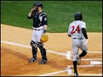  Mud Hens catcher Bryan Holaday waits for the throw as Felix Pie crosses the plate for Indianapolis at Fifth Third Field.