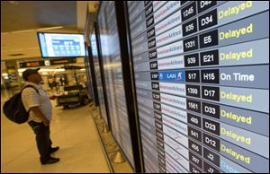 An unidentified passenger checks the flight information board at the Miami International Airport, Tuesday, during American Airlines outage which resulted in delayed and canceled flights.