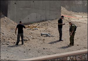 Israeli security investigates the scene of a rocket attack in Eilat, Israel, today.