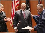  Phil Copeland is applauded by his daughter Sarah Copeland, after being sworn in as Lucas County recorder by Toledo Municipal Court Judge C. Allen McConnell, right, at One Government Center in Toledo, Friday, January 4, 2013.
