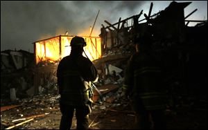 Firefighters use flashlights to search a destroyed apartment complex near a fertilizer plant that exploded.