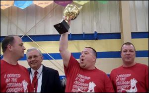 Shawn Zaborski hoists the trophy as winner of the 2013 Polish-American Community of Toledo’s Kielbasa Cook-off, making his team, Polish Village Kielbasa, the 'Kielbasa King' for the year. Celebrating with him are, from left, Ladden Vernon; Stan Machosky, president of the PACT board of directors, and Eric Smigelski. 
