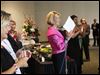  Event co-Chair Cindy Taylor, center, claps as she names off the Pink Tie Guys, men who have helped in the search for a cure for cancer, Saturday evening during the Pink Ribbon Gala at the SeaGate Convention Centre in downtown Toledo.