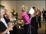  Event co-Chair Cindy Taylor, center, claps as she names off the Pink Tie Guys, men who have helped in the search for a cure for cancer, Saturday evening during the Pink Ribbon Gala at the SeaGate Convention Centre in downtown Toledo.