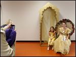 Andrea Sheriff, of Sylvania, left, snaps a picture of her daughter Ivy, 8, center, with Belle, played by Kayla Maseman, 17.