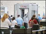  Travelers move through a security checkpoint in the McNamara Terminal of  Detroit Metropolitan Airport.