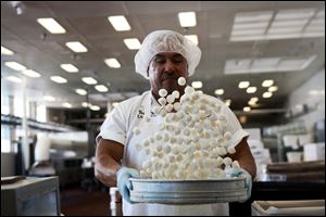 New technologies have led to a gradual workforce reduction over the years at the See's Candies factory in Los Angeles, California, but theres still plenty done by hand. Above, Arturo Barboza tosses house-made honey marshmallows, the start of the company's Rocky Road eggs.
