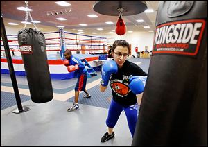 Four-time national Police Athletic League winner Monica Van Pelt, 17, works out at a punching bag during at the league’s temporary facility at the former Riverside Hospital in North Toledo.