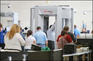 Travelers move through a security checkpoint in the McNamara Terminal of  Detroit Metropolitan Airport.