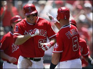 Los Angeles Angels' Mike Trout is congratulated by Albert Pujols, right, after hitting a grand slam off of Detroit Tigers starting pitcher Rick Porcello during the first inning Saturday in Anaheim, Calif.
