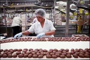 New technologies have led to a gradual workforce reduction over the years at the See's Candies factory in Los Angeles, California, but theres still plenty done by hand. Above, Bertha Ramos sorts through freshly-coated chocolate marshmallow eggs before they are sent off to be boxed and packaged. 