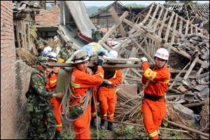 Rescuers carry out an elderly paralyzed person from a collapsed house after an earthquake struck, in Qingren Township, Lushan County, Ya'an City, southwest China's Sichuan Province, Saturday.
