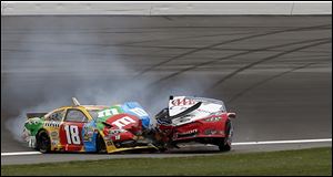 The cars of Kyle Busch (18) and Joey Logano got stuck together after a violent wreck that sent debris across the track.