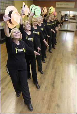 Dancers, including Ann Smith, left, use hats during a swing dance during adult tap lessons.