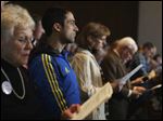 In his Boston Marathon runner’s jacket, David Delmar, 28, second from left, a member of Trinity Episcopal Church in Boston, attends a service at Temple Israel. U.S. officials believe the danger has passed.