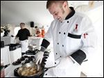  Chef Dave Harrison, from  Poco Piatti, cooks scallops  during Taste of the Nation Toledo at the Toledo Club. Forty area businesses and three celebrity chefs cooked up a storm at Sunday’s event.