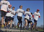  George Roche, who ran in the Boston Marathon and crossed the finish line 20 minutes before the bombing, sings the Pledge of Allegiance with other runners who participated in the nationwide solidarity run at Woodlands Park in Perrysburg.