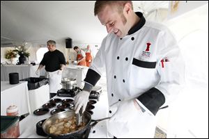 Chef Dave Harrison, from  Poco Piatti, cooks scallops  during Taste of the Nation Toledo at the Toledo Club. Forty area businesses and three celebrity chefs cooked up a storm at Sunday’s event.