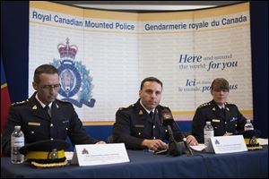 Assistant Commissioner James Maliza, officer in charge of Federal Policing Operations, center, is flanked by Chief Superintendent Gaetan Courchesne, Royal Canadian Mounted Police criminal operations officer in the province of Quebec, left, and Chief Superintendent Jennifer Strachan RCMP criminal operations officer in the province of Ontario at a press conference in Toronto today.