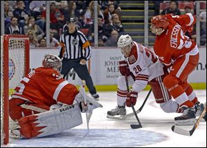 Red Wings goaltender Jimmy Howard stops a shot by Phoenix center Lauri Korpikoski as defenseman Jonathan Ericsson moves in.