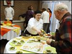  Culinary student Amber Simmet, center, serves food today at Owens Garde Manger Grazing Stations Buffet.