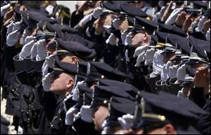 Police officers salute during a memorial service for fallen Massachusetts Institute of Technology campus officer Sean Collier at MIT in Cambridge, Mass. 