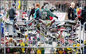 Running shoes hang from a barrier at a makeshift memorial in Copley Square in Boston, which reopened on Wednesday for the first time since the two bombings during the marathon on April 15.