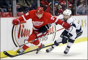 The Red Wings’ Damien Brunner, left, battles the Kings’ Jarret Stoll for the puck. The Wings picked up two key points with a 3-1 win.