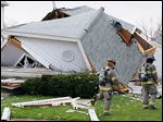  Toledo police and firefighters examine a house at 1448 N. Huron St. that collapsed after a large explosion Thursday.