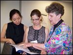  Katherine Chon, left, and Mara Vanderslice Kelly, both from the U.S. Department of Health and Human Services, talk with Sister Geraldine Nowak about a new recommendations to fight modern-day slavery.