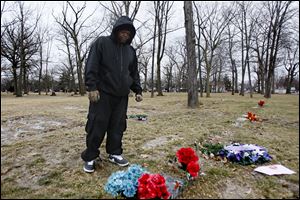 Mitchell Moore stands at the grave site of his son Montrese Moore, who died at the age of 19 in a shooting at the corner of Cherry and Bancroft streets.